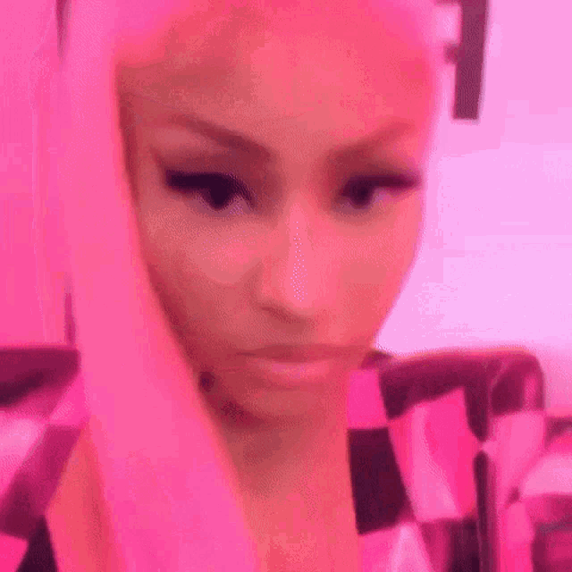 a close up of a woman 's face with a pink background .