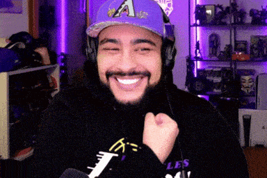 a man wearing headphones and a hat with the letter a on it is smiling