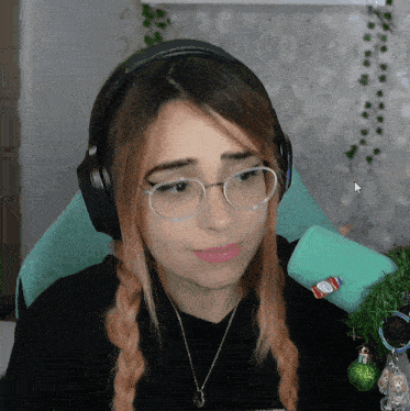 a woman wearing headphones and glasses is looking down