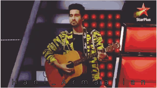 a man is holding a guitar in front of a star plus sign