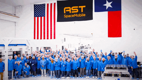 a large group of people are posing in front of a ast spacemobile flag