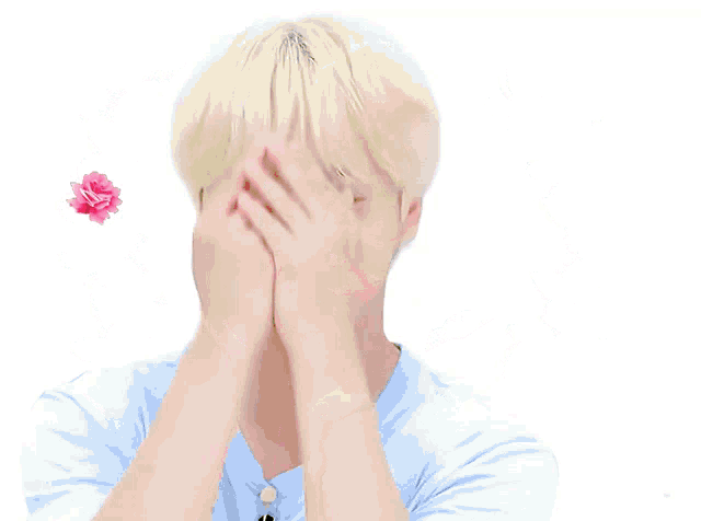 a young man with blonde hair is surrounded by pink flowers and leaves
