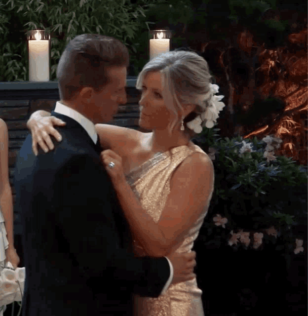 a bride and groom are hugging each other in front of candles