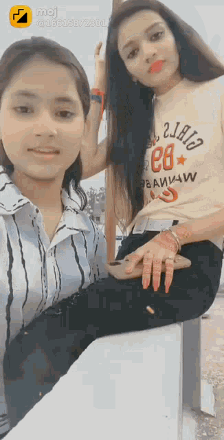 two girls are posing for a picture and one has a shirt that says e8