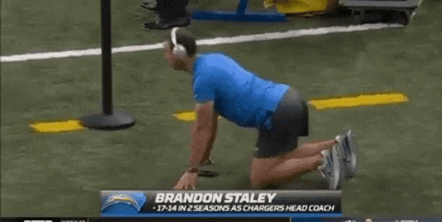 a man is kneeling down on a field with the name brandon staley on the screen