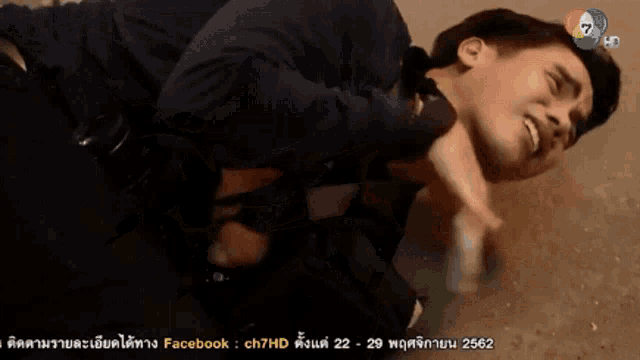a man is laying on the ground with his head on another man 's neck .