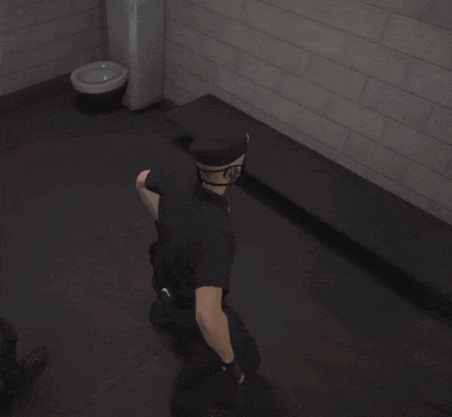 a police officer is kneeling down in front of a brick wall
