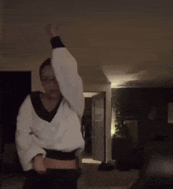 a woman wearing glasses is dancing in a dark room .