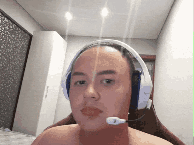 a shirtless man wearing headphones with a microphone