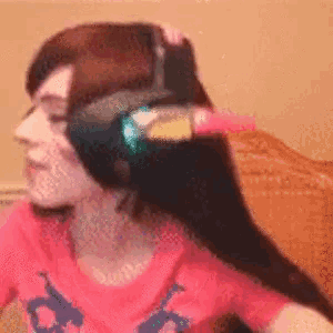 a pixelated image of a woman wearing headphones and a pink shirt with the letter s on it