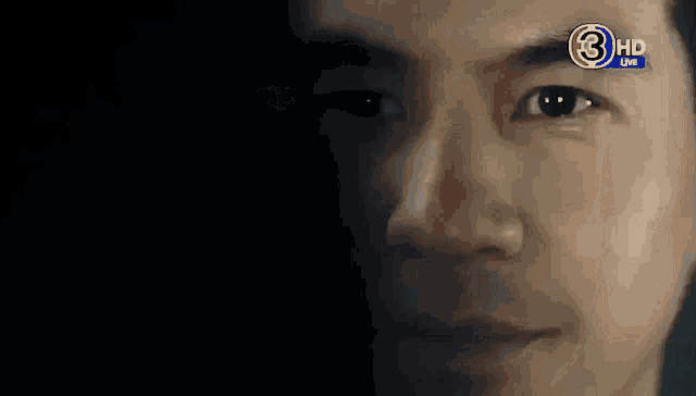 a close up of a man 's face with the number 3 hd on his forehead