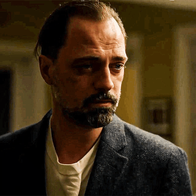 a man with a beard wearing a suit and white shirt