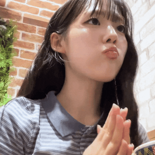 a girl with long hair is making a funny face with her hands