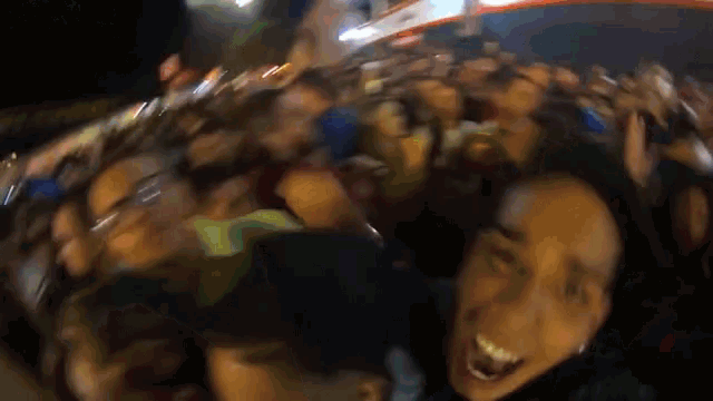 a blurry picture of a crowd of people with a woman making a face