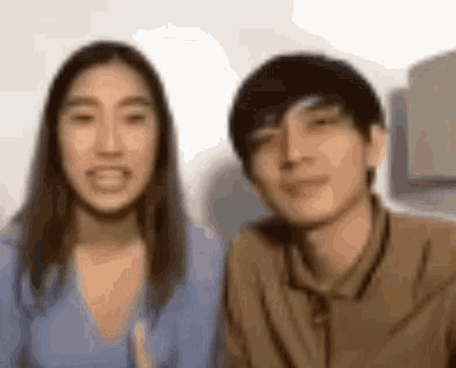 a blurry picture of a man and a woman looking at the camera .