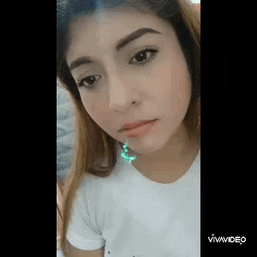 a close up of a woman 's face with a green lightning bolt in her mouth .