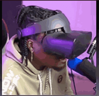 a man wearing a virtual reality headset is sitting in front of a microphone .