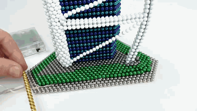 a person is playing with a toy made of magnets and beads