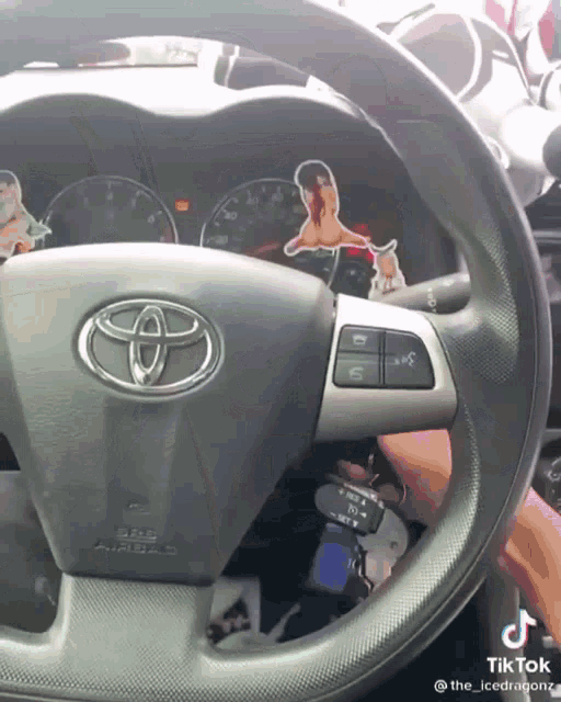 a person is driving a toyota with a sticker on the steering wheel that says tiktok