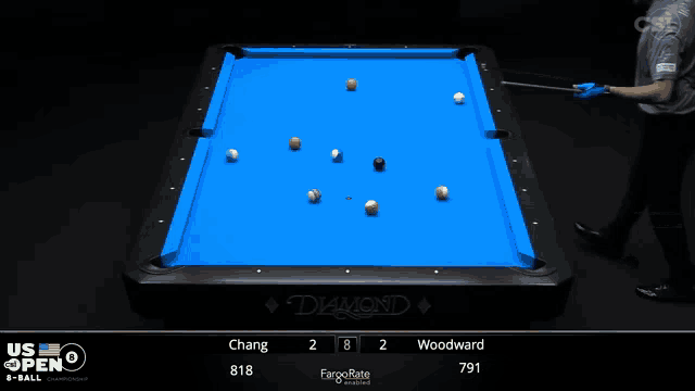 a pool table with a blue cloth and a person holding a cue