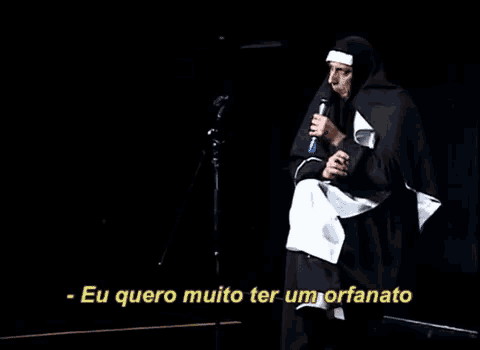 a man dressed as a nun is holding a microphone and saying eu quero muito ter um orfanato