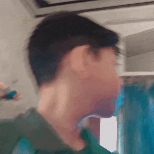 a blurry picture of a person 's face with a green shirt on