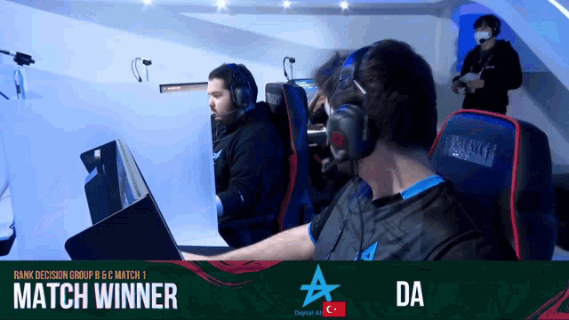 a man wearing headphones sits in front of a screen that says match winner on it