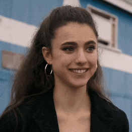 a close up of a woman wearing hoop earrings and a black jacket .