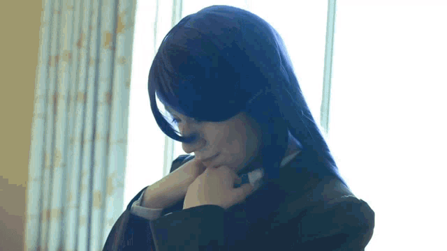 a woman in a purple wig looks down at something