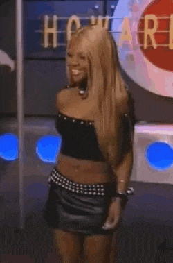 a woman in a black crop top and a black skirt is standing in front of a sign that says howard .