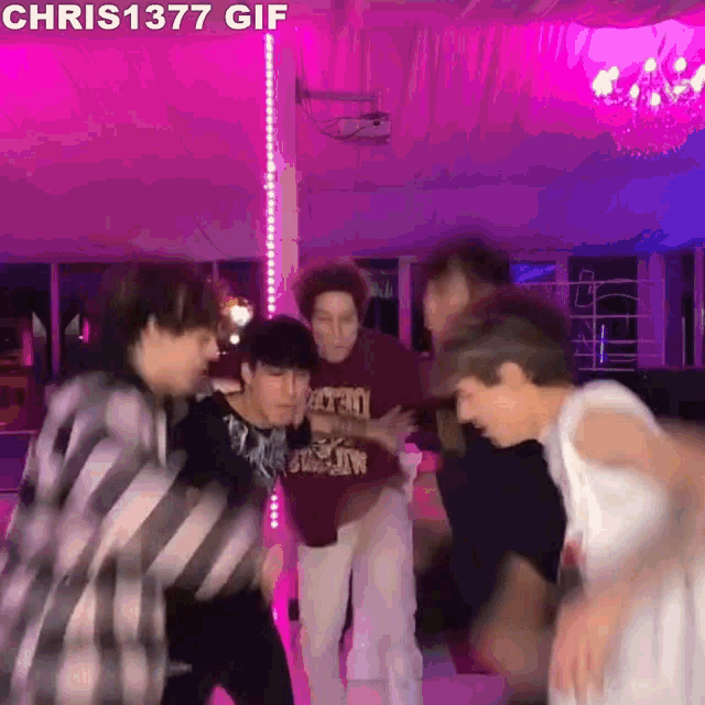 a group of young men are dancing together in a room .