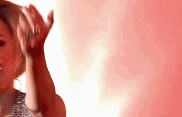 a woman in a striped shirt is dancing with her hands in the air