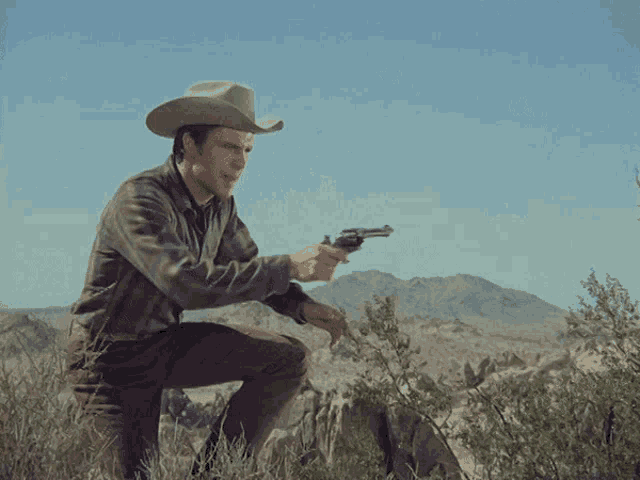 a man in a cowboy hat is holding a gun
