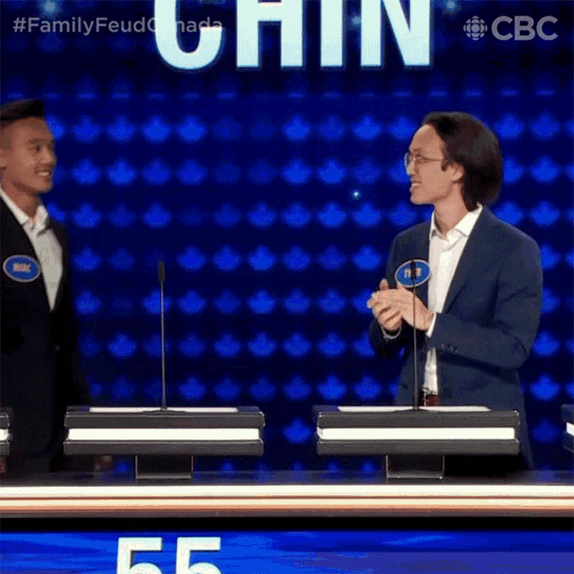 two men standing in front of a microphone with the word chin in the background
