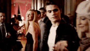 a man and a woman are standing next to each other in a crowd of people at a party .