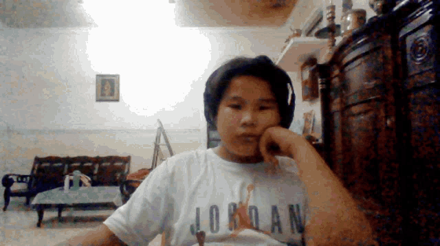 a young boy wearing a white jordan shirt