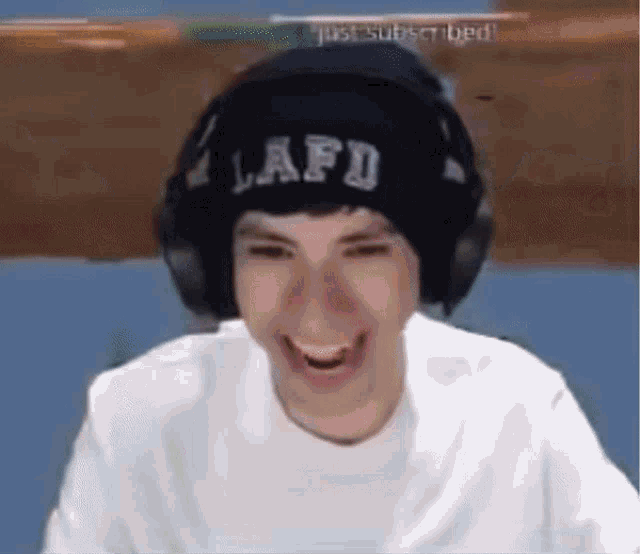 a man wearing a beanie and headphones is laughing .