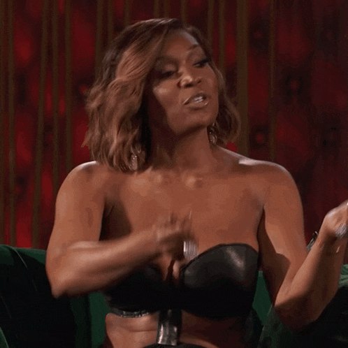 a woman in a strapless bra is sitting on a green couch