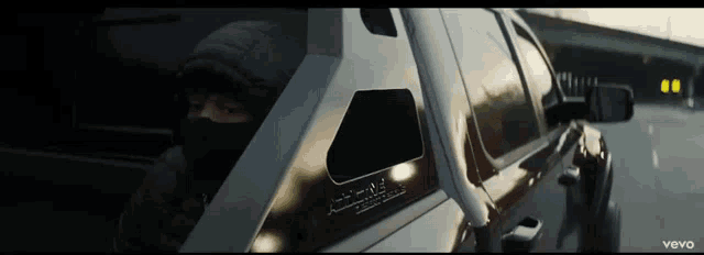 a man in a mask is sitting in a car with the word vevo on the side