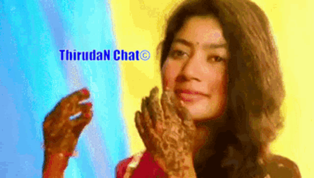 a woman with a henna tattoo on her hand is standing in front of a sign that says thiruda chat