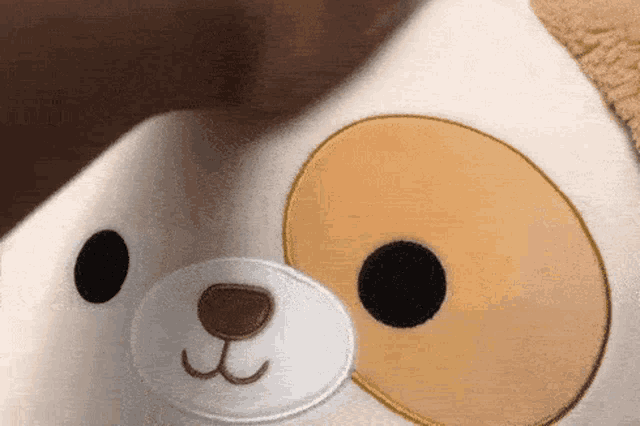 a close up of a stuffed animal with a dog face on it