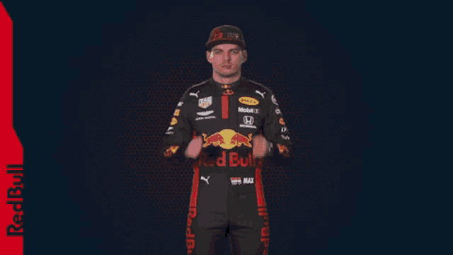 a man in a red bull racing suit is clapping his hands