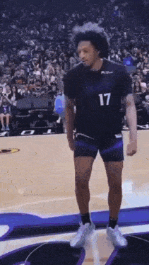a basketball player wearing a number 17 jersey is dancing on the court .