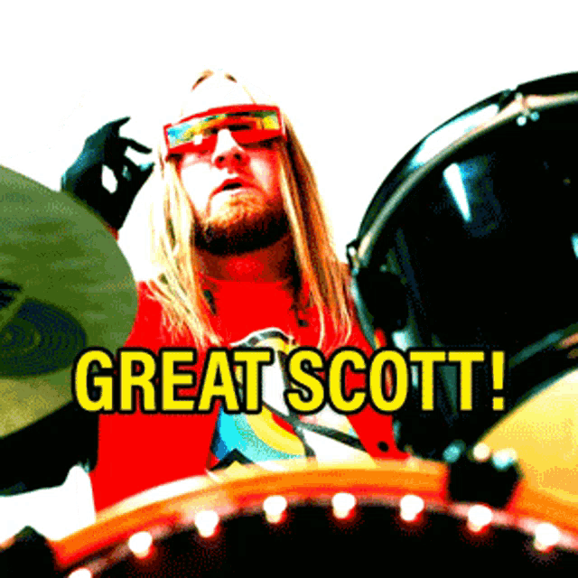 a man wearing a red shirt that says great scott playing drums