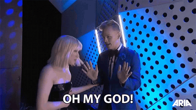 a man in a tuxedo and a woman in a strapless dress are talking and the man is saying oh my god