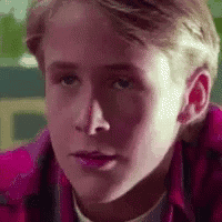 a close up of a young man 's face wearing a pink shirt .