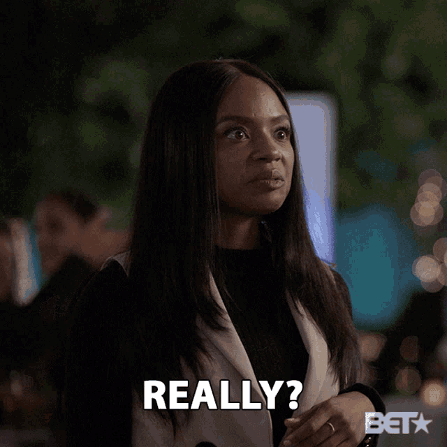 a woman in a white vest says really