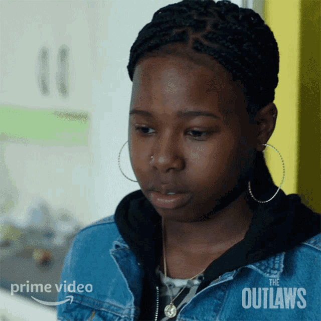 a woman wearing hoop earrings and a denim jacket is featured in a prime video ad
