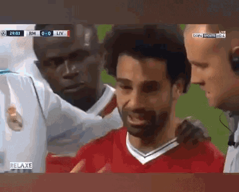 a man in a red shirt is being helped by another man during a soccer game .