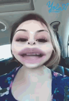 a woman is making a funny face in a car with the word yolo written on the bottom right
